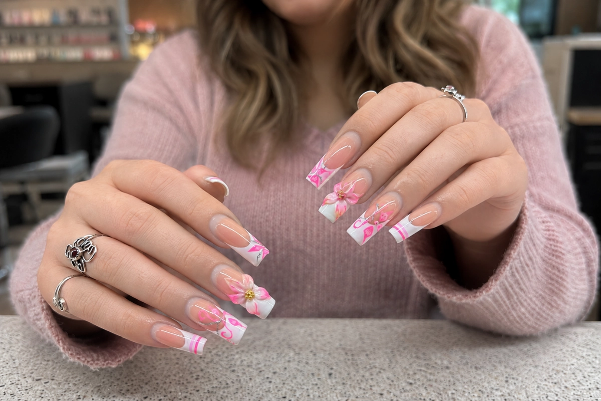 Client showing a pink acrylic nail set