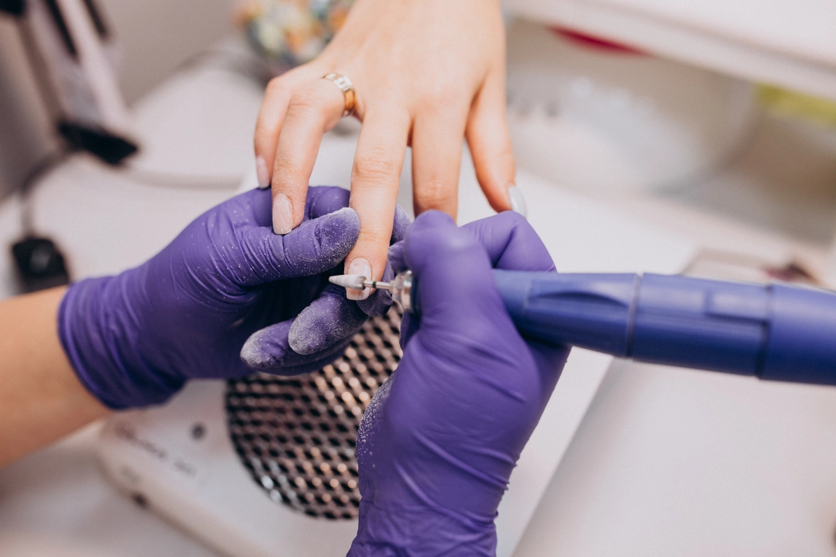 Nail technician maintaining an acrylic nail